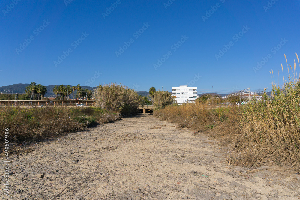Dry river with hurdle around it on a beach in Premia de Mar - obrazy, fototapety, plakaty 