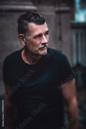 portrait of handsome man in his 50s wearing a black t-shirt