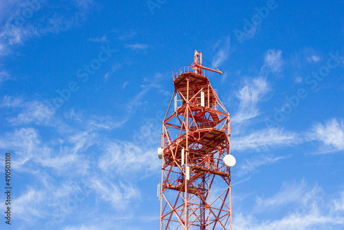 a television cell tower on the border of two states against a blue sky, the front and back backgrounds are blurred with a bokeh effect