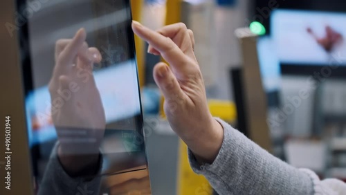 A woman's hand touches the screen of the self-service checkout covid shoping closeup photo