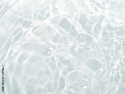 Blurred ripple water texture on white background. Shadow of water on sunlight. Mockup for product, spa or travel background. Marble water surface as wallpaper background