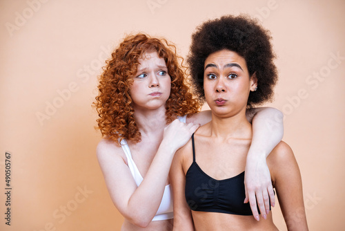 beauty image of two young women with different skin and body posing in studio for a body positive photoshooting. Mixed female models in lingerie on colored backgrounds © oneinchpunch