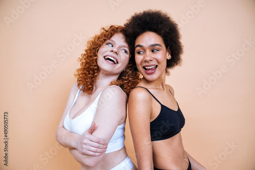 beauty image of two young women with different skin and body posing in studio for a body positive photoshooting. Mixed female models in lingerie on colored backgrounds © oneinchpunch