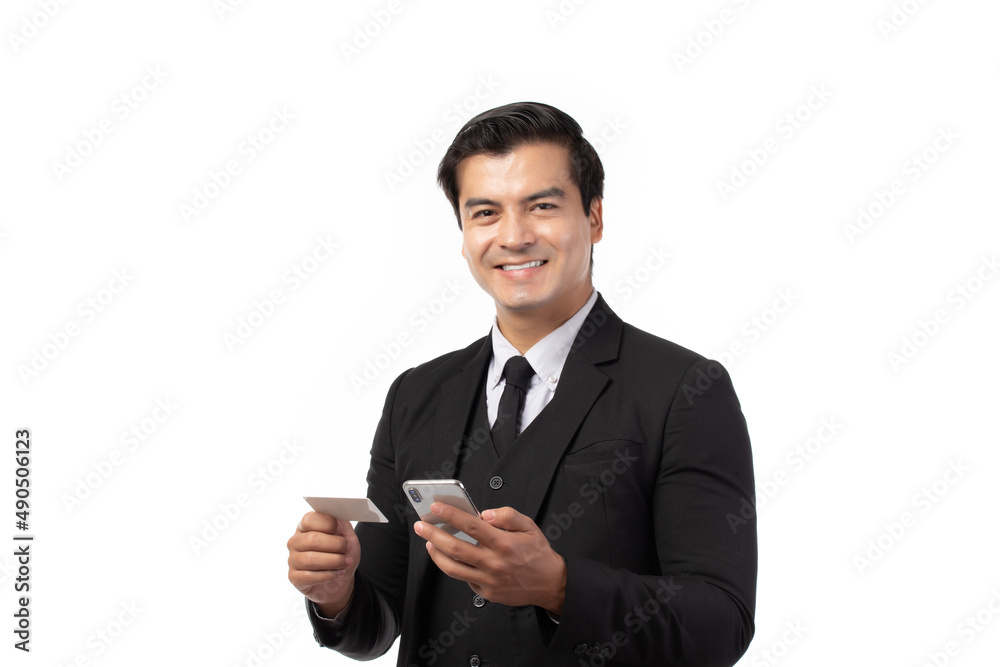 Handsome business man in black suit holding credit card and using smartphone for online shopping isolated on white background. Business, technology, ecommerce and online payment concept. Handsome business man in black suit holding credit card and using smartphone for online shopping isolated on white background. Business, technology, ecommerce and online payment concept.