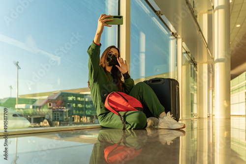 Woman on video call sitting on airport floor