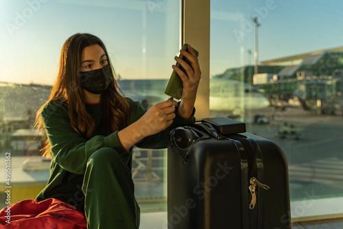Obraz na płótnie Young girl at the airport charging her smartphone w salonie
