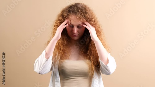 Young woman fottball fan with red hair touching her temples with hands, she can not beleive her team lost the game. photo