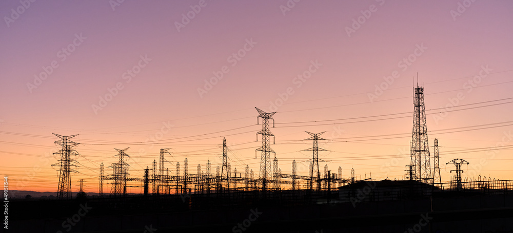 Silhouettes of electric towers during a sunset with vivid colours