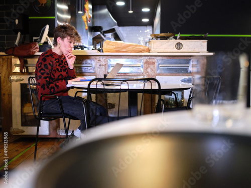 Foto Worried woman working in the management of a restaurant with a laptop