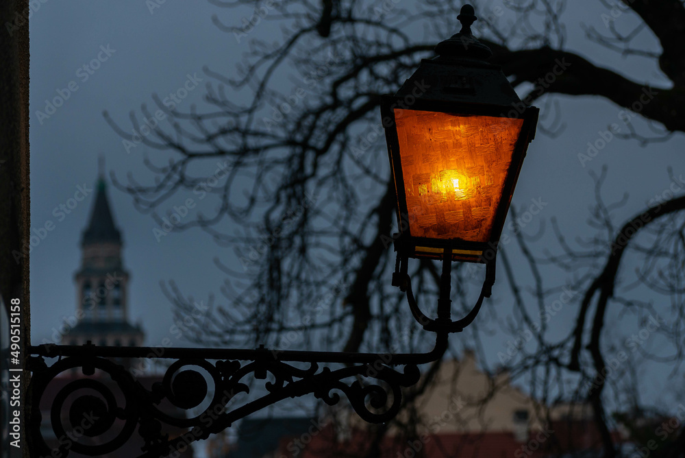 Zaświecona stara kuta latarnia, pomarańczowe światło, Bielsko-Biała. Zaświecona stara kuta latarnia, pomarańczowe światło, Bielsko-Biała.