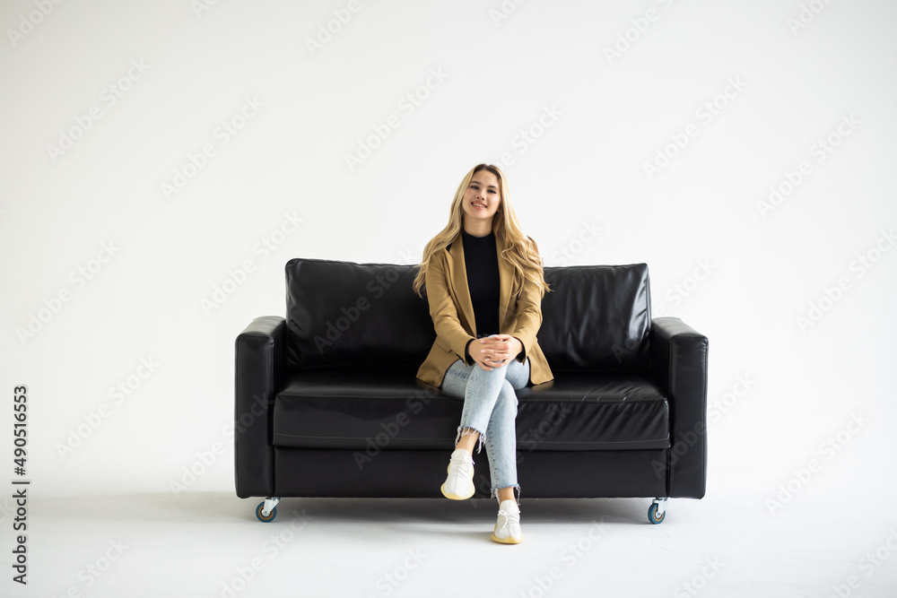 Woman resting on a sofa and holding a phone isolated on white background Woman resting on a sofa and holding a phone isolated on white background