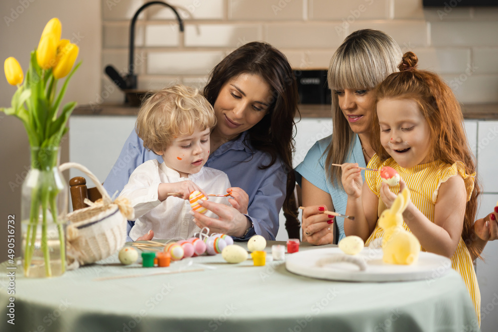 Mothers with their children paint eggs in preparation for the Easter holidays Mothers with their children paint eggs in preparation for the Easter holidays