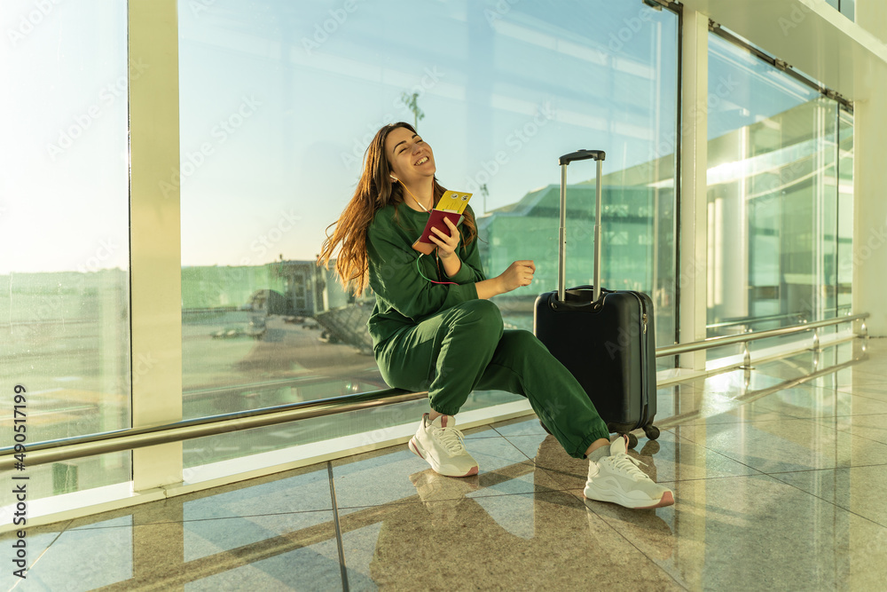 Girl dancing at the airport with her headphones.