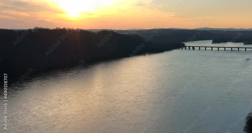 Aerial pullback of river in undeveloped nature. Bridge crosses body of water. Beautiful winter sunset. Aerial pullback of river in undeveloped nature. Bridge crosses body of water. Beautiful winter sunset.