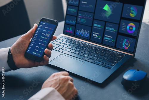 Stock market investment. Trader or broker analysing graphic cryptocurrencies and stocks financial data on phone.Financial Technology. Business strategy and digital marketing concept. 