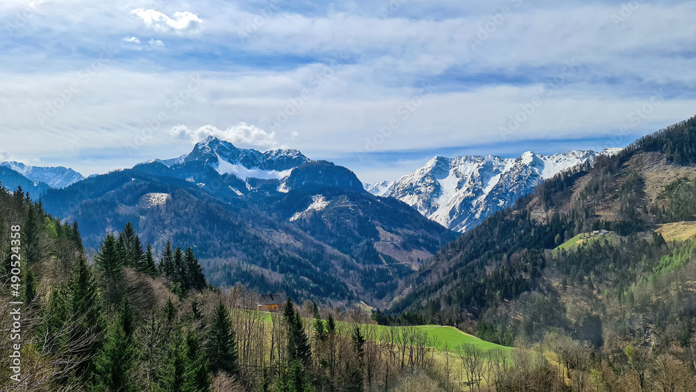 Scenic view of snow capped mountain peaks of Karawanks near Sinacher Gupf in Carinthia, Austria. Mount Wertatscha and Hochstuhl (Stol) is visible in early spring. Hills in Rosental on sunny day. Hike