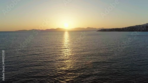 Fly over the palm trees to a scenic sunset view - Aerial wide angle shot of a sunset at Bodrum