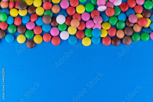 Multi-colored candies on a blue background. Copy space.