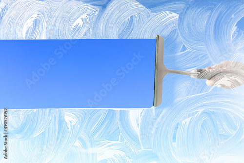 Bild auf Leinwand Washing of window with detergent and squeegee against blue sky