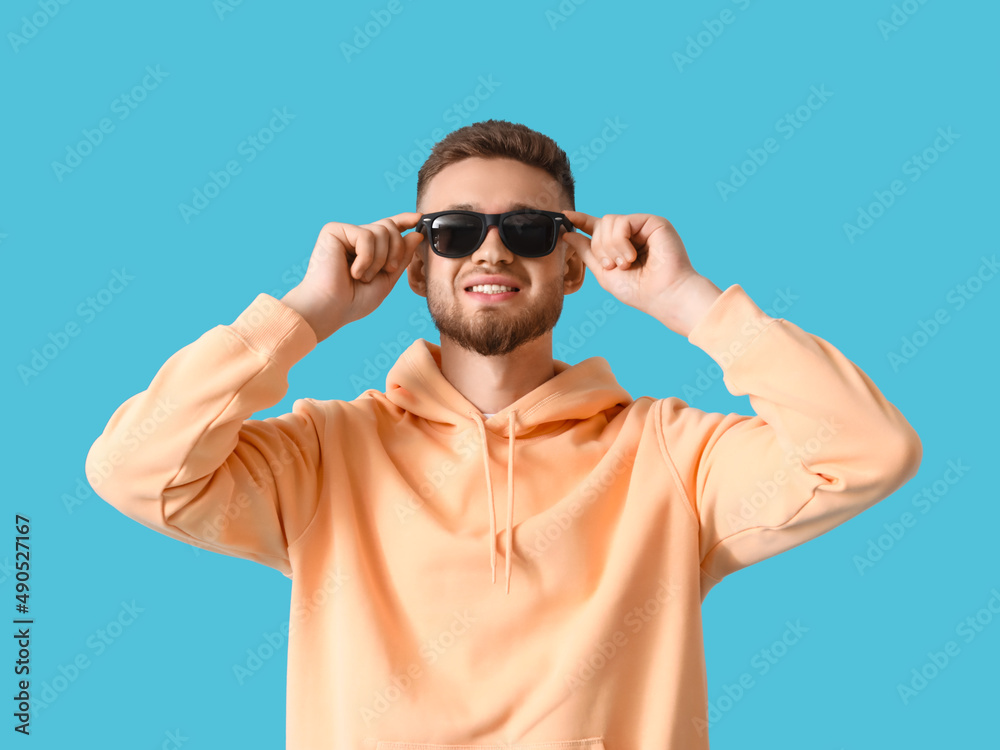 Fototapeta premium Young guy in stylish hoodie on color background