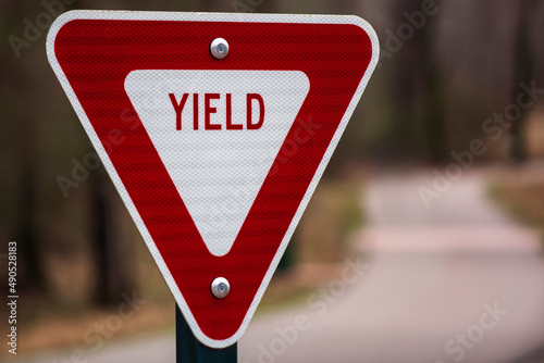 Photo of a YIELD sign with a path in the background
