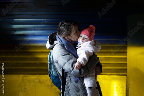 A loving mother holding her child in her arms in the underground shelter photo