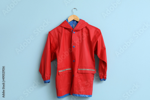 Child's raincoat hanging on blue wall
