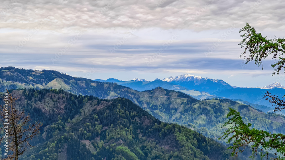 Panoramic view on the Eisenerzer Alps from below mount Roethelstein near Mixnitz in Styria, Austria. Snow capped mountain of the Ennstal Alps beyond the Grazer Bergland in Styria, Austria. Overcast Panoramic view on the Eisenerzer Alps from below mount Roethelstein near Mixnitz in Styria, Austria. Snow capped mountain of the Ennstal Alps beyond the Grazer Bergland in Styria, Austria. Overcast