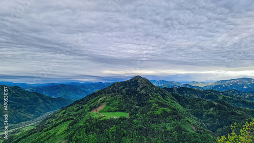 Scenic view from mount Roethelstein near Mixnitz in Styria  Austria. Landscape of green alpine meadow  bushes and high grass in the valley of Grazer Bergland in Styria  Austria. Cloudscape