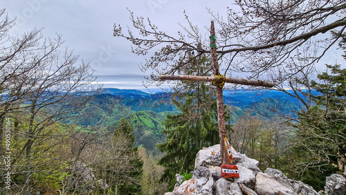 Small wooden summit cross of mount Roethelstein near Mixnitz in Styria, Austria. Landscape of green alpine meadows and woodlands in the valley of Grazer Bergland in Styria, Austria. Lake photo