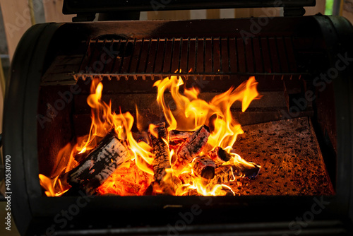 Hot empty charcoal barbecue grill with bright flame. Soft selective focus.