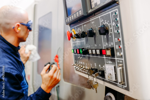 Side view of caucasian energy plant worker in working clothes on head turning on switch.