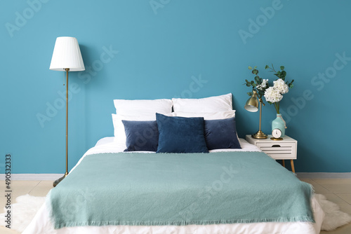 Comfortable bed, vase with ...