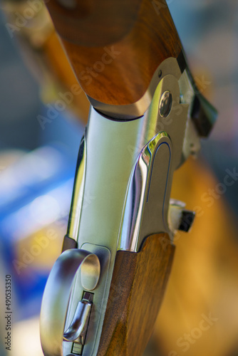 Close-up of an open, unloaded double-barreled shotgun at a sports shooting range. Blurred back. photo