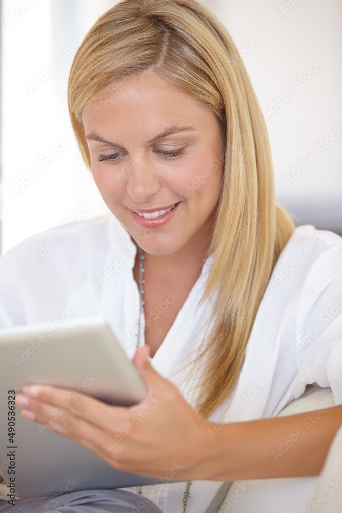 Checking her work schedule. A beautiful young blonde woman working on her digital touchpad. Checking her work schedule. A beautiful young blonde woman working on her digital touchpad.
