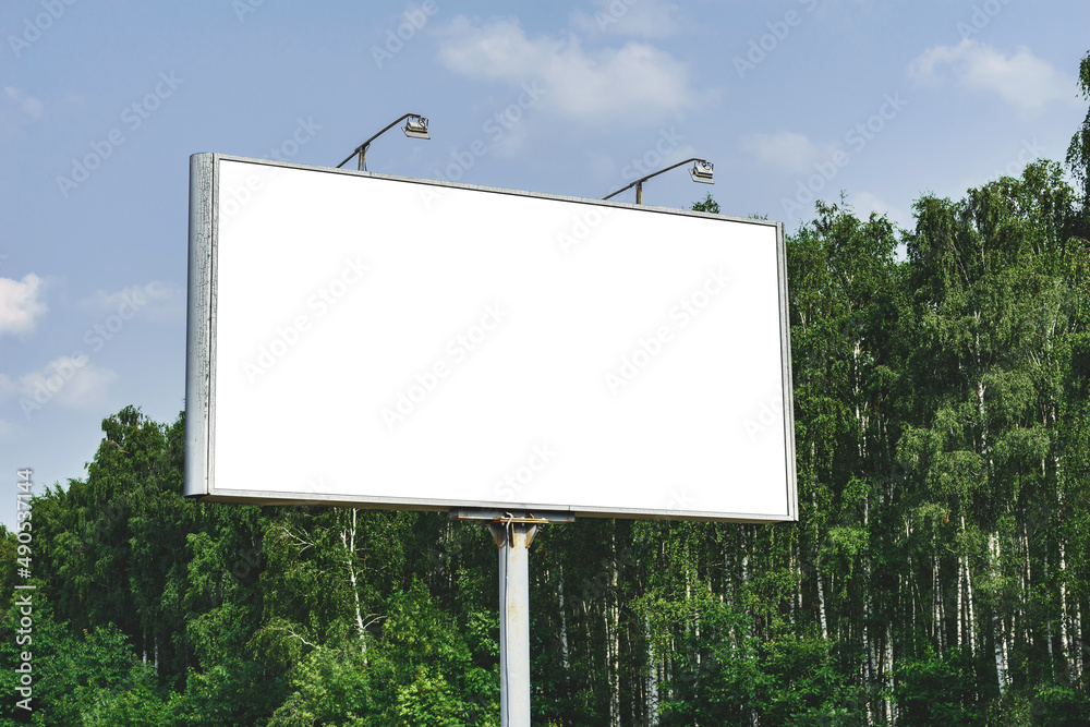 Blank billboard mockup with white screen. Against the backdrop of nature and blue sky. Business concept. Copy space banner for advertising. Blank billboard mockup with white screen. Against the backdrop of nature and blue sky. Business concept. Copy space banner for advertising.