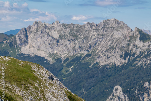 Panoramic view from Messnerin on the alpine mountain chains in Styria, Austria, Hochschwab region. Hills overgrown with small bushes, higher parts rocky and bare. Summer day. Hiking in Alps, Tragoess