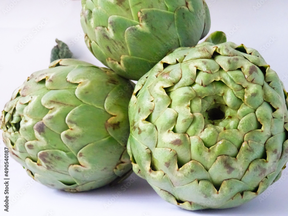 Close-up of a group of fresh flowers of artichokes isolated over a white background Close-up of a group of fresh flowers of artichokes isolated over a white background