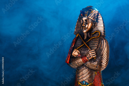 Foto egyptian golden pharaoh statue in blue fog on black background