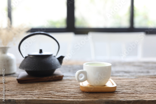 White tea cup and black metal teapot