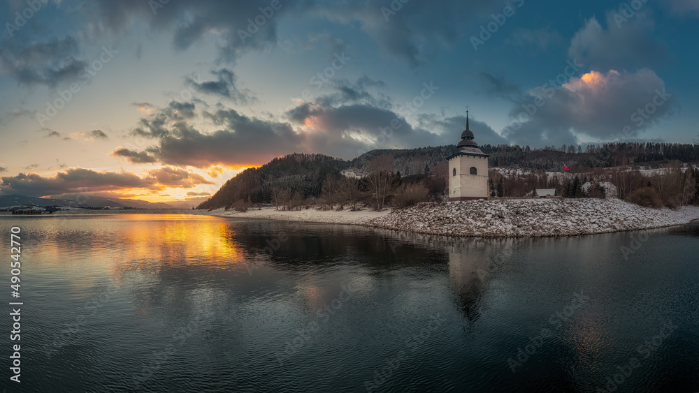 sunset on the coast of the Liptovska Mara dam with the tower of the old church
