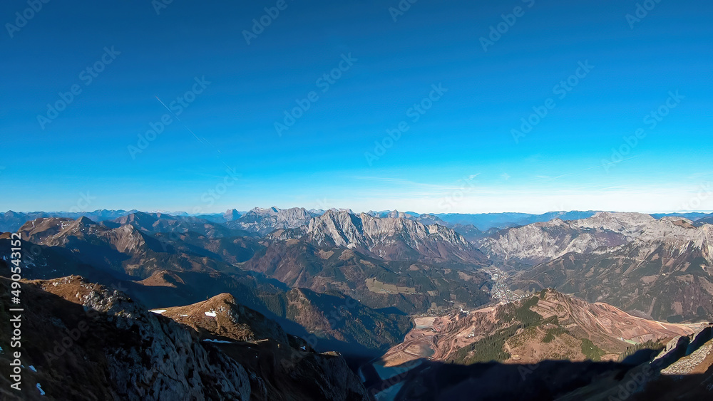 A panoramic view from mount Eisenerzer Reichenstein in Styria, Austria, Europe. Austrian Alps. View on the village Eisenerz and the lakes in the Ennstal valley. Hiking trail, Wanderlust. Sunny day