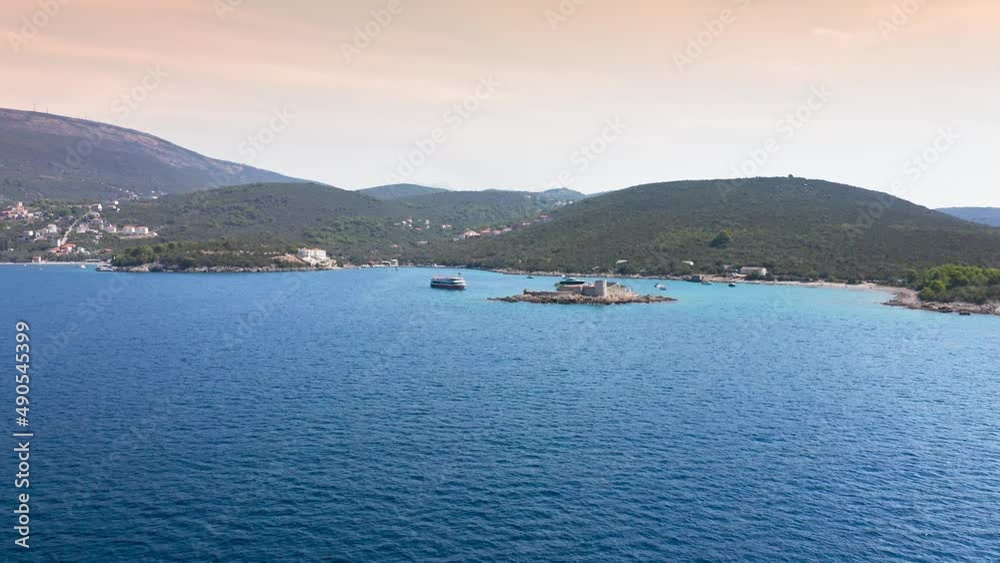 Top view of the island with a fortress. View from the Lustica peninsula to the island of Otocic Gospa. Castle on the island of Otocic Gospa. Montenegro. Drone. Catamarans in bay. Pleasure boats in the Top view of the island with a fortress. View from the Lustica peninsula to the island of Otocic Gospa. Castle on the island of Otocic Gospa. Montenegro. Drone. Catamarans in bay. Pleasure boats in the