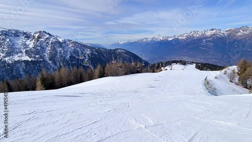 Skiers descending mountain in deep snow powder in Aprica, Italy