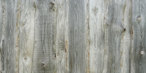 Panoramic banner of wooden wall texture close up. Natural wood background. Old wooden wall of a house made of vertical planks in the countryside.