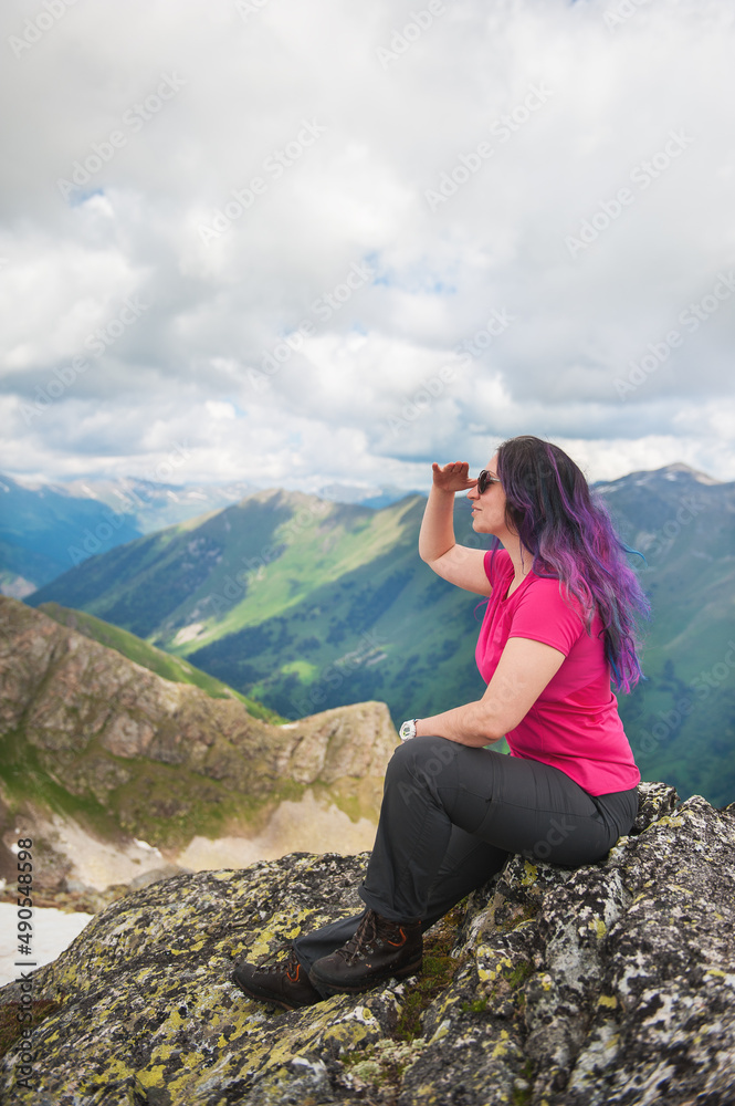 Beautiful Woman hiker sitting on the top of mountain