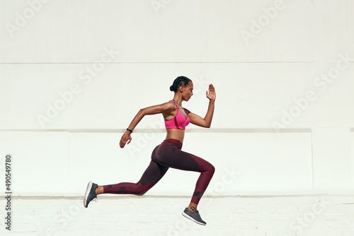 Whether you go slow or fast, just go. Shot of a sporty young woman out running.