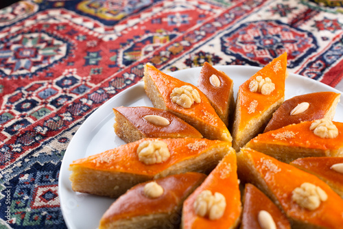 Plate of Azerbaijani national pastries for Novruz pakhlava and shakarbura on ethnic rug or carpet for Novruz, spring equinox and new year celebration in March. Copy space  