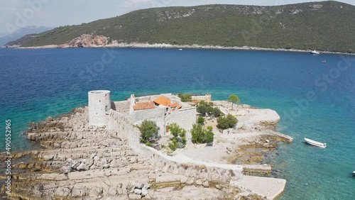 Castle on the island of Otocic Gospa in the Bay of Kotor. Montenegro. Top view of the island with a fortress. Drone. Pleasure boats in the bay. 
 photo