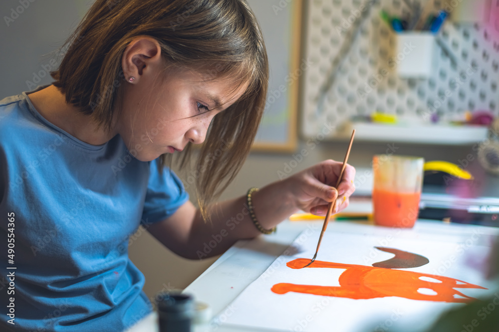 cute girl at home at the table draws with paints cute girl at home at the table draws with paints
